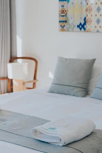 a white towel is sitting on a bed at Pandanus Palms Holiday Resort in Point Lookout