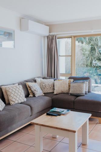 a living room with a couch and a coffee table at Pandanus Palms Holiday Resort in Point Lookout