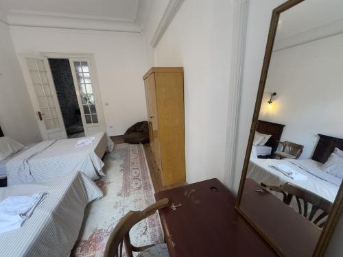 a room with two beds and a mirror at Granada private bedroom for men only in Alexandria