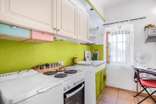 - une cuisine avec des murs verts et des plaques de cuisson blanches dans l'établissement Bastidon la Deprat, à Sanary-sur-Mer