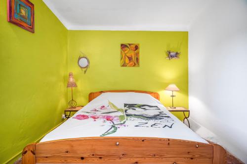 - une chambre avec un lit en bois dans un mur vert dans l'établissement Bastidon la Deprat, à Sanary-sur-Mer