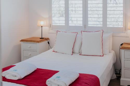 a bedroom with a white bed with two pillows at Pandanus Palms Holiday Resort in Point Lookout