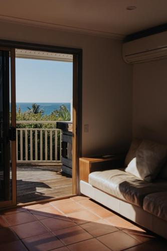 a bedroom with a bed and a door to a balcony at Pandanus Palms Holiday Resort in Point Lookout