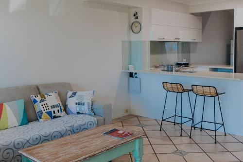 a living room with a couch and a kitchen at Pandanus Palms Holiday Resort in Point Lookout