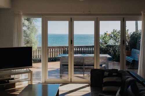 a living room with a view of the ocean at Pandanus Palms Holiday Resort in Point Lookout