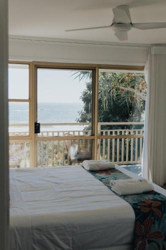 a bedroom with a bed with a view of the ocean at Pandanus Palms Holiday Resort in Point Lookout