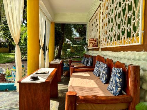 a room with two beds and two tables at Casa Hera Diani in Diani Beach