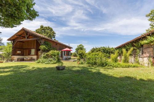a house in a yard with a large grass field at Gite du platane in Bélis