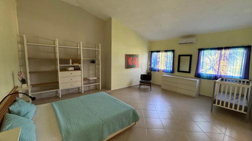 a bedroom with a bed and a crib and windows at Caleton Group in Río San Juan