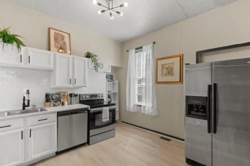 a kitchen with white cabinets and stainless steel appliances at 2BD Flat Near Cherokee Arts with Game Room vibes! in Saint Louis