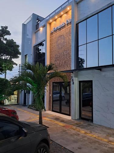 a building with a palm tree in front of it at Apartamento por temporada no centro de Macapá - mobiliado in Macapá