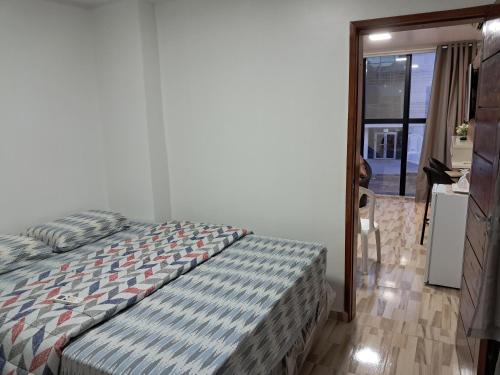 a bedroom with a bed with a striped comforter at Apartamento por temporada no centro de Macapá - mobiliado in Macapá