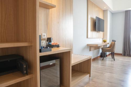 a hotel room with a desk and a tv in a room at Aston Gresik Hotel & Conference Center in Gresik