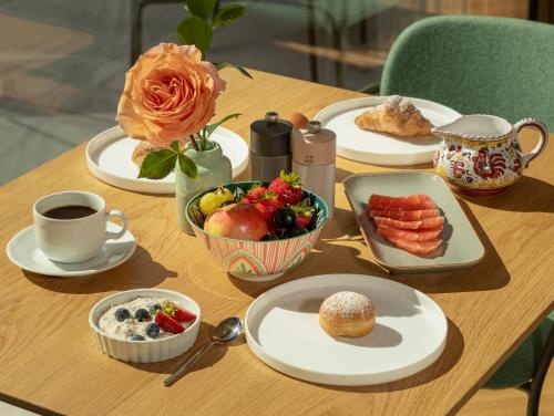 a table with plates of food and a bowl of fruit at Pension Höfler - Fernblick in Schenna