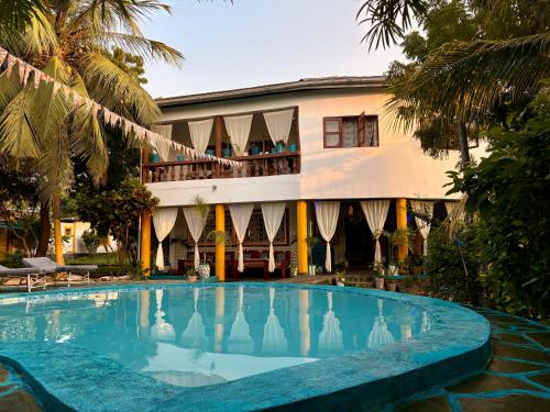 a hotel with a swimming pool in front of a building at Casa Hera Diani in Diani Beach