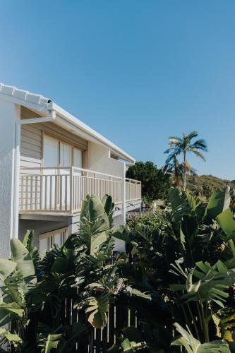a house with a lot of plants in front of it at Pandanus Palms Holiday Resort in Point Lookout