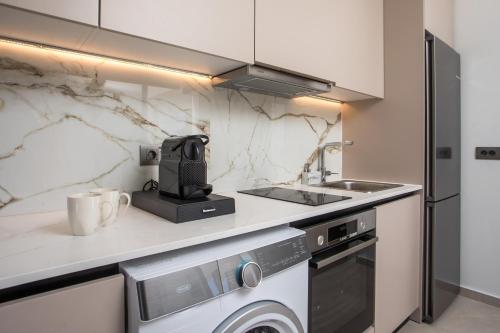a kitchen with a sink and a dishwasher and a counter at Nostos Luxury Apartments in Kremasti