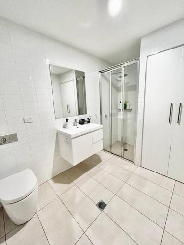 a white bathroom with a toilet and a shower at Black Diamond by ParberyProperty in Kingston 