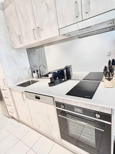 a kitchen with white cabinets and a sink at Black Diamond by ParberyProperty in Kingston 