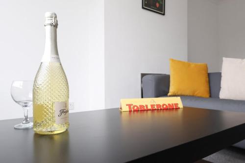 a bottle of champagne and a wine glass on a table at Central Bath Getaway with WiFi in Bath