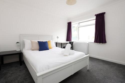 a white bed in a room with a window at Central Bath Getaway with WiFi in Bath