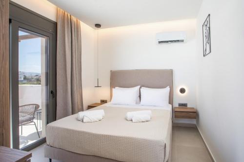 a bedroom with a bed with two white pillows at Nostos Luxury Apartments in Kremasti