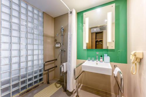 un baño con lavabo y espejo en Holiday Inn Express Hangzhou Huanglong, en Hangzhou