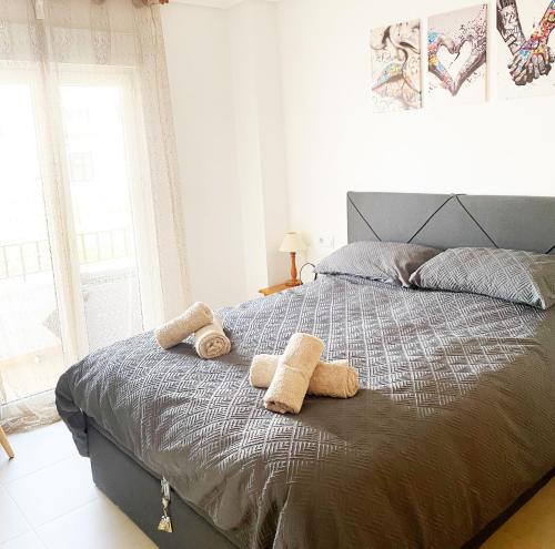 Un dormitorio con una cama con dos toallas encima. en Delightful Ground Floor 2 bed with access to pool, Wi-Fi, AC, en Sucina