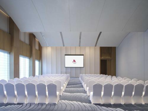 an empty room with white chairs and a white screen at Beihai Marriott Resort in Beihai