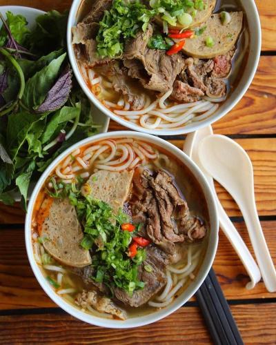 two bowls of beef noodle soup on a table at Ari Boutique Hotel in Ho Chi Minh City