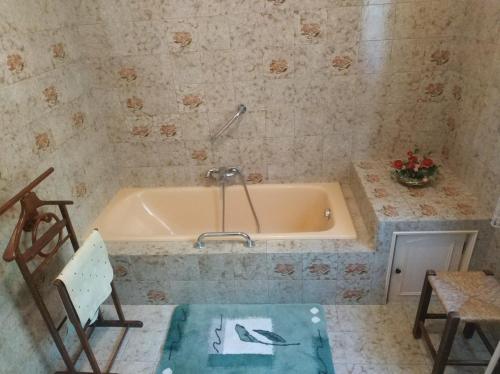 a bath tub in a bathroom with a table and a chair at L'Enclos du Château in Courthézon