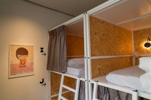 En eller flere senger på et rom på 暖南小安民宿The Warm Tain-An Hostel-台南火車站-新樓醫院-背包客房-可包層-可包房-可包棟-獨旅友善民宿
