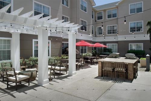 a pergola with tables and chairs in front of a building at Homewood Suites by Hilton Newark-Cranford in Cranford