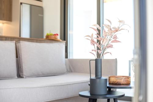 a vase on a table next to a couch at Nostos Luxury Apartments in Kremasti