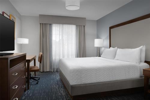 a hotel room with a bed and a desk and a television at Homewood Suites by Hilton Newark-Cranford in Cranford