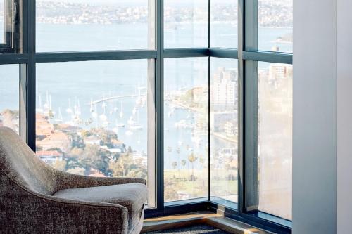 a chair sitting in front of a large window at Meriton Suites North Sydney in Sydney