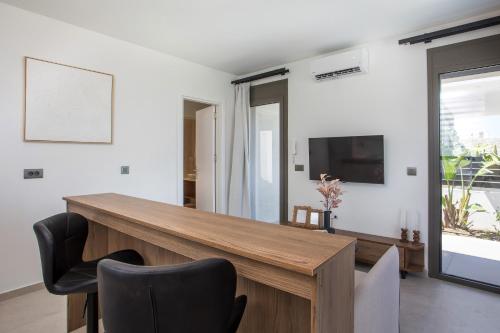a dining room with a wooden table and chairs at Nostos Luxury Apartments in Kremasti