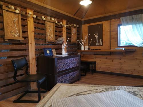 a room with a chair and a wooden wall at Alejas Namiņš in Jurģi