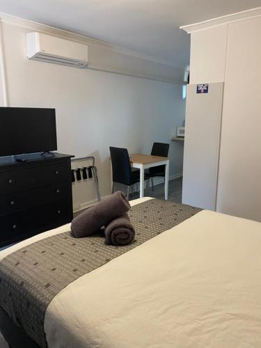 a bedroom with a bed and a table and chairs at Corrigin Windmill Motel in Corrigin