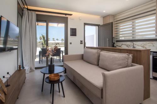a living room with a couch and a table at Nostos Luxury Apartments in Kremasti