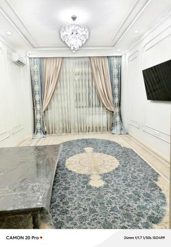 a living room with a large rug and a chandelier at Cozy Stay in Dushanbe