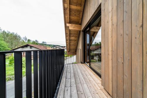 a wooden deck with glass doors on a house at Detailliebe - Sonne und Stil in Waging am See