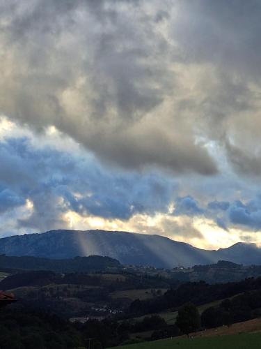 a cloudy sky with mountains in the distance at Casa Rural Areano in Escoriaza
