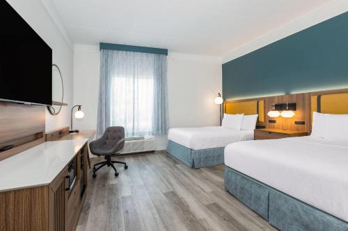 a hotel room with two beds and a desk at La Quinta by Wyndham Sherman in Sherman
