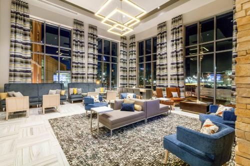 a lobby with couches and chairs and windows at Cambria Hotel Pittsburgh - Downtown in Pittsburgh