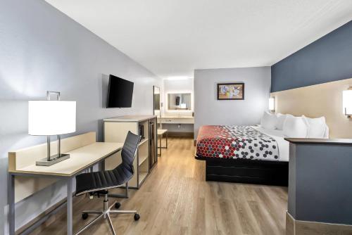a hotel room with a bed and a desk and a computer at Econo Lodge Inn & Suites Cayce I-26 Airport in Cayce