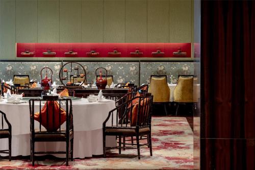 a dining room with a table and chairs in a restaurant at Kempinski Hotel Xiamen in Xiamen