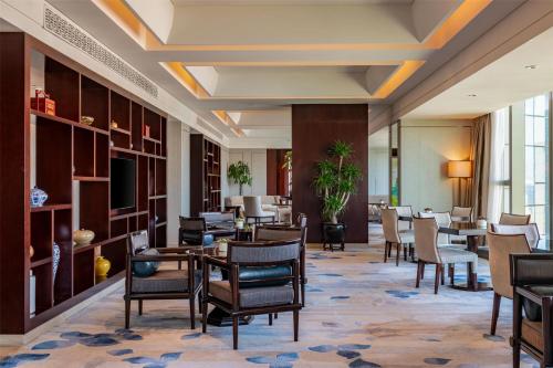 a lobby of a hotel with tables and chairs at Kempinski Hotel Xiamen in Xiamen