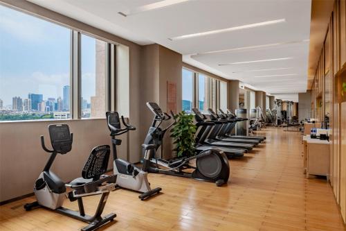 a gym with a row of treadmills and exercise bikes at Kempinski Hotel Xiamen in Xiamen