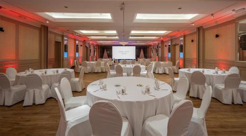 a room with white tables and chairs and a screen at Grand Hyatt La Manga Club Golf & Spa in La Manga del Mar Menor
